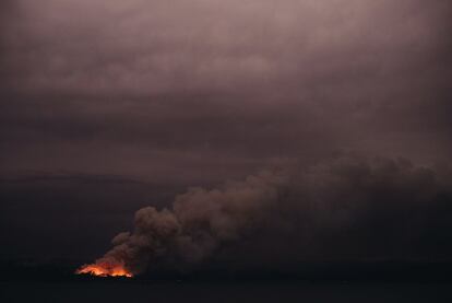 Vista general de un incendio desde el barco 'HMAS Adelaide' de la Armada Real Australiana frente a la costa de Eden en Nueva Gales del Sur (Australia), durante una operación de socorro.