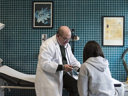 El médico Xosé María Dios toma la tensión a una joven en el centro de salud de Outes.