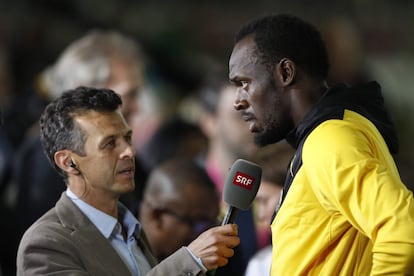 Usain Bolt habla con un periodista tras la carrera.