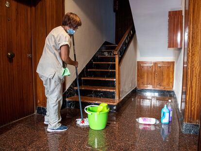 Una empleada realiza labores de limpieza en el portal de un edificio en Toledo.