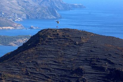 Un helicóptero se dispone a refrescar la superficie afectada por el incendio en Cap de Creus.