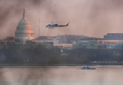 A helicopter flies near the crash site of the American Airlines plane on the Potomac River.