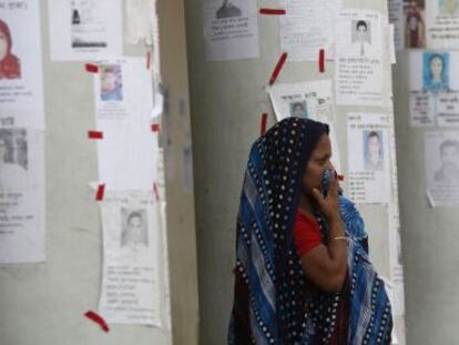 Una mujer rodeada de carteles de desaparecidos en la tragedia del Rana Plaza.