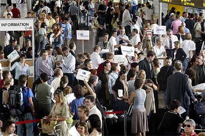 Viajeros de la operación retorno y participantes en el congreso abarrotaron ayer el aeropuerto de El Prat.