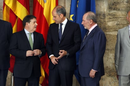 José Luis Olivas, Francisco Camps y Rodrigo Rato, ayer, en el Palau de la Generalitat. Están flanqueados por los presidentes de la Caja Insular de Canarias y Caja Ávila.