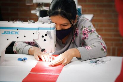 Una mujer aprende a operar una máquina en la sala de confección y costura de la 'Manzana del Cuidado' de Kennedy, en Bogotá.