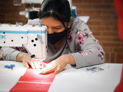 Una mujer aprende a operar una máquina en la sala de confección y costura de la 'Manzana del Cuidado' de Kennedy, en Bogotá.