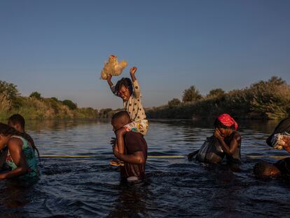 Migrantes haitianos cruzan el lunes el río Grande, en Texas, camino de México.