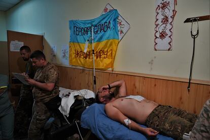 Un militar herido leve espera su traslado a otro hospital en un pasillo del punto médico donde ha sido atendido cerca del frente de Zaporiyia. 