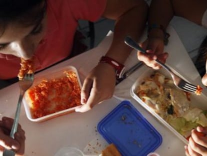 Dos niñas en edad escolar comen comida preparada en casa.