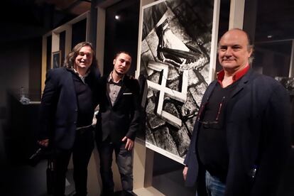  El comisario Andreu Català (hijo de Francesc Català-Roca), Mark Català (nieto de Francesc Català) y Rafeel Català (hijo de Pere Català i Roca), junto al famoso cartel de su abuelo y bisabuelo Pere Català i Pic en el Museo de Historia de Cataluña.