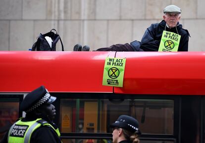 Las protestas comenzaron el pasado día 15 y desde entonces la policía metropolitana de Londres ha efectuado más de un millar de detenciones a personas vinculadas con los actos de protesta. En la imagen, un hombre se sienta en la parte superior de un tren mientras los manifestantes bloquean el tráfico en la estación Canary Wharf en Londres (Reino Unido), el 25 de abril de 2019.