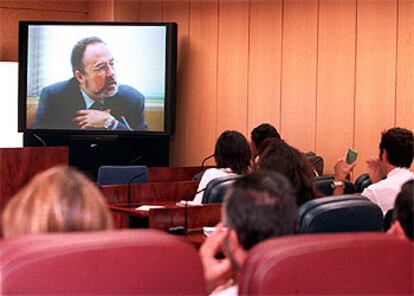 Los periodistas escuchan a través de un monitor la comparecencia del diputado tránsfuga del PSOE Eduardo Tamayo.