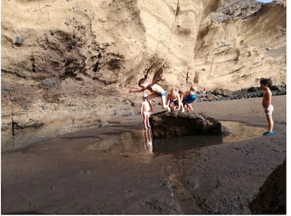 La playa puede ser un espacio de aprendizaje fundamental este verano. En la imagen varios niños, alumnos de la playa escuela El Médano, juegan en los charcos de la playa en un día de escuela.