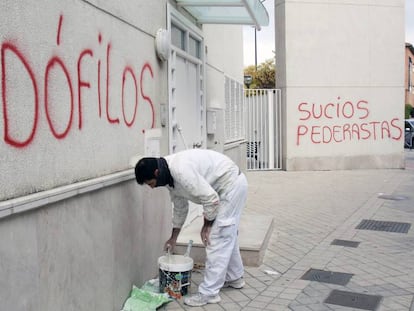 Un pintor cubre una pintada en la parroquia donde ejerc&iacute;a el padre Rom&aacute;n, en 2014. 