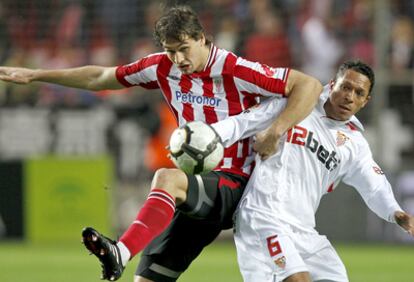 Fernando Llorente disputa el balón con el sevillista Adriano.