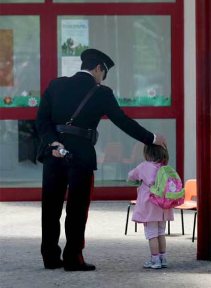 Un 'carabiniere' italiano acaricia la cabeza de una niña en la enfermería de la escuela Olga Rovere, en Rignano Flaminio, cerca de Roma.