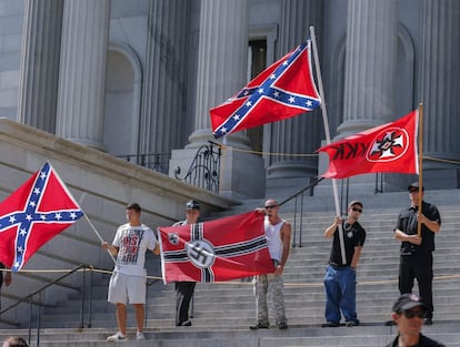 Miembros del Ku Klux Klan ondean banderas confederadas en las escaleras del Capitolio.