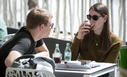 Dos jóvenes toman unos refrescos en una terraza en Barcelona