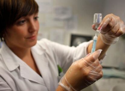 Una enfermera prepara una dosis de la vacuna contra la gripe A en un centro de salud de Valencia.