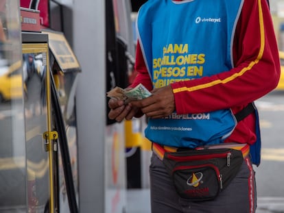 Un despachador de gasolina cuenta billetes en una estación de servicio en Cali, el 8 de junio de 2023.