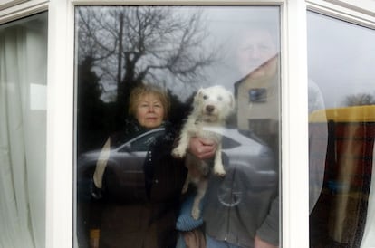 Angela Tunstall posa con su marido, Stephen de 62 años y uno de sus dos perros, dentro de su casa en el pueblo inundado de Moorland. Angela asegura que lo primero que rescataría de su casa serían sus dos mascotas.