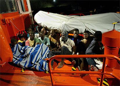 Algunos de los inmigrantes rescatados tratan de recuperarse a bordo de la lancha de Salvamento Marítimo que los trasladó al muelle de Gran Tarajal.