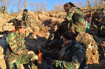 Un grupo de 'peshmergas' iraníes del PAK hacía un fuego para calentarse, tras realizar maniobras en una zona montañosa próxima a la frontera con Irán, el pasado 2 de enero.