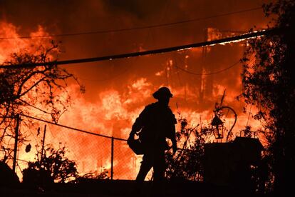 Un bombero lucha contra el fuego de una casa en llamas en Malibú (California), el 9 de noviembre de 2018.