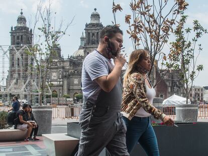 Dos personas fuman en una de las avenidas que rodean el Zócalo, en el Centro Histórico de Ciudad de México.