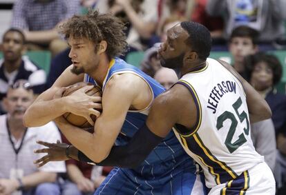 Al Jefferson, de Utah, lucha por el balón con Robin Lopez, de Nueva Horleans