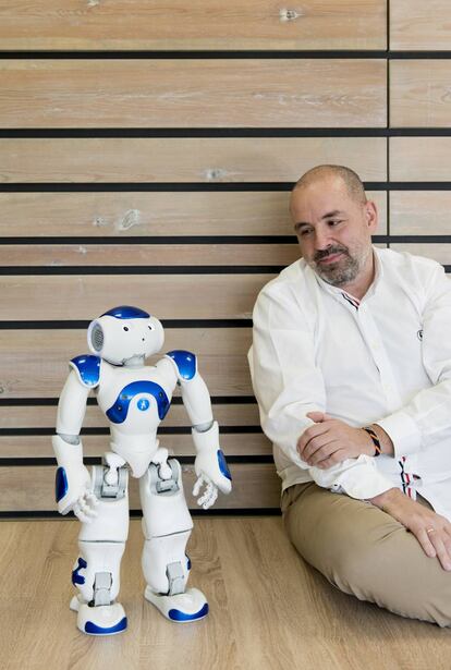 El gerente de sistemas, Manuel de Arcocha, con un robot al que se ha instalado un chatbot para resolver dudas sobre envases.