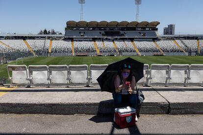 Una mujer se resguarda del calor en el estadio Monumental de Santiago.