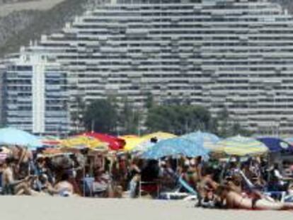 Veraneantes disfrutan al pie de los apartamentos de la playa de Cullera, en Valencia. EFE/Archivo