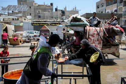 Una mujer recibe comida de una organización benéfica mientras la gente huye de Rafah, este miércoles. 