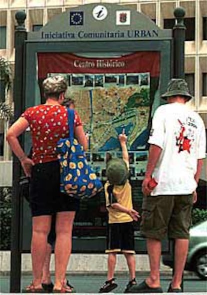 Una familia de turistas observaba ayer un plano de Málaga.
