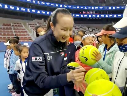 Peng Shuai firma pelotas de tenis durante un torneo infantil, este domingo en Pekín.