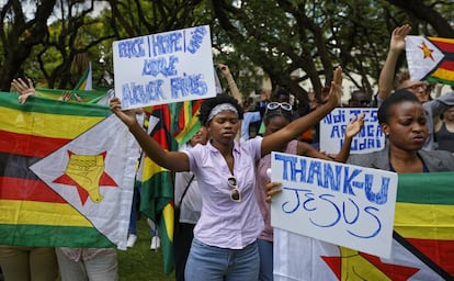 Zimbabuenses en una concentración cristiana con pancartas que dicen "Gracias Jesús" o "Paz, esperanza, unidad, amor, nunca fallan" el 20 de noviembre en Harare (Zimbabue).