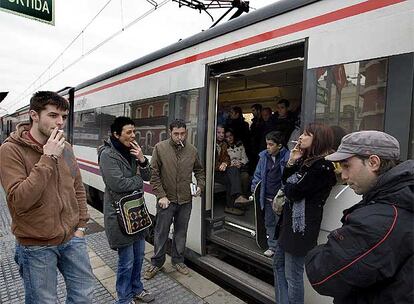 Pasajeros esperan fuera de un tren en la estación de Montcada i Reixac durante la avería por la caida de la catenaria.