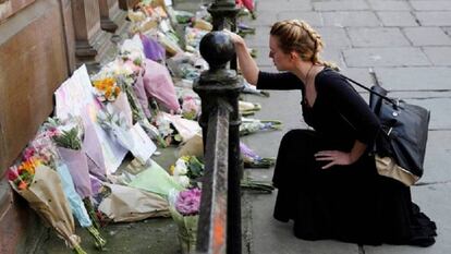 Una mujer deja flores por las víctimas del atentado en el Manchester Arena en mayo.