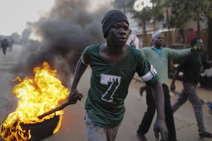 Un simpatizante del líder de la oposición arrastra una llanta en llamas durante una protesta pobre de Kibera, en Nairobi, el 9 de agosto.