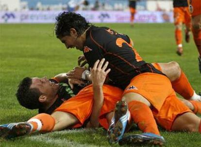 David Navarro (a la izquierda), Banega y otro compañero celebran el gol del triunfo valencianista en La Rosaleda.