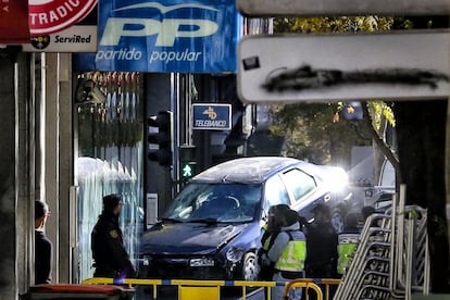 Una grúa retira el coche que un hombre empotró en la sede del PP, en diciembre de 2014.