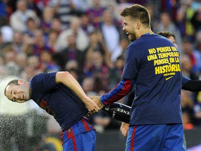 Piqué ducha con champán a Iniesta tras ganar la Liga el domingo en el Camp Nou.