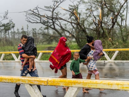 Una familia camina en Pinar del Río tras el paso del huracán 'Ian'.