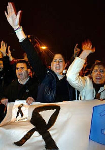 Un grupo de manifestantes grita bajo la lluvia en la manifestación de Madrid.