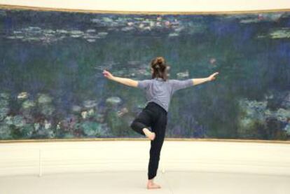 Bailarina del Centro Nacional de Danza Contemporánea de Angers frente a uno de los paneles de ‘Nenúfares’ en el Museo de la Orangerie de París.