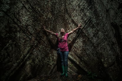 La climatóloga brasileña Luciana Gatti sonríe junto a un árbol de samaúma gigante, en el bosque nacional de Tapajós.