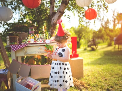 Little girl drinking juice on a birthday party outdoors,day