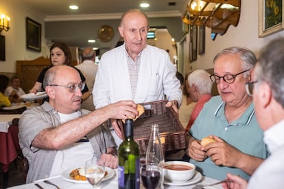 González ofrece pan en la mesa de sus amigos Antonio Alonso, Severino Hernández y Antonio Álvarez.

